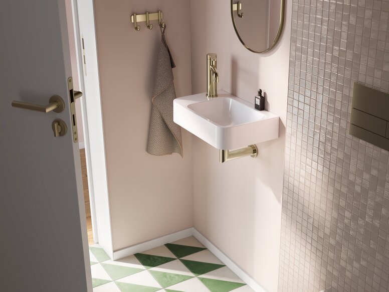 A rectangular washbasin with a tap and a siphon in the wash area, set against a beige wall with beige tiles