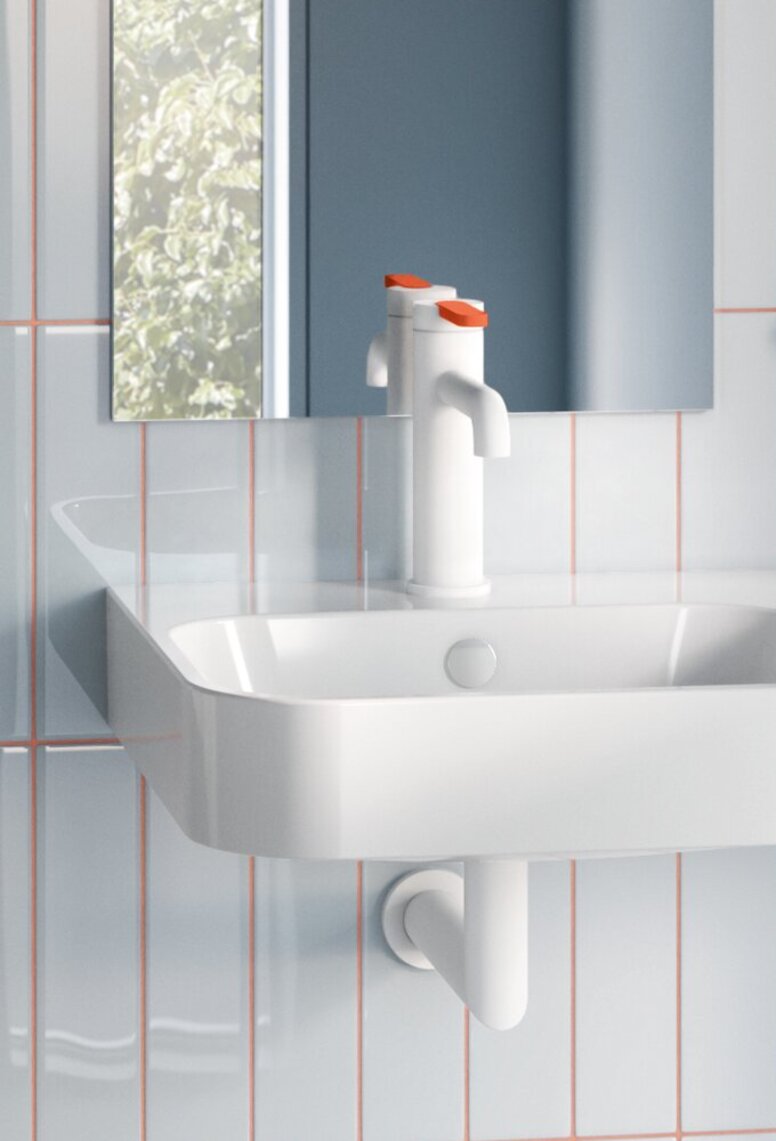 WC mit klappbarem Haltegriff seitlich und Haltegriff hinter dem WC in einem barrierefreien Bad mit einem kompakten Handwaschbecken