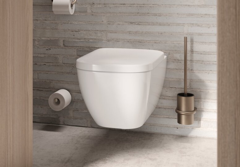 Wandhängendes WC mit bronzefarbener PVD-Beschichtung bei der Toilettenbürste, dem WC-Papierhalter und dem Reservepapierhalter