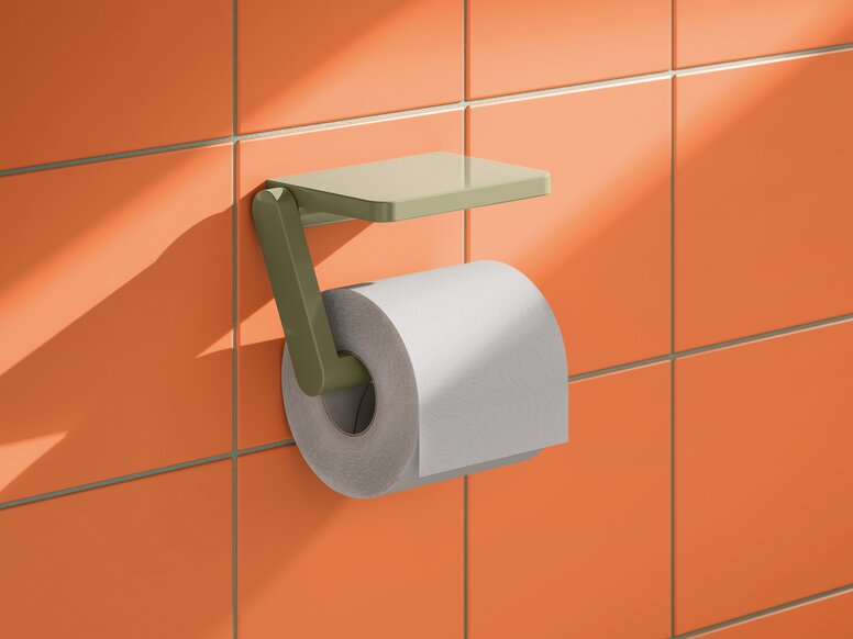 HEWI System 700 toilet roll holder with shelf Green toilet roll holder with a toilet roll and rectangular shelf on an orange tiled wall