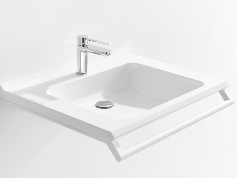 Weißer Waschtisch mit einer rechteckigen Beckenmulde, einem verchromtem Wasserhahn und einem Haltegriff an der Vorderkante