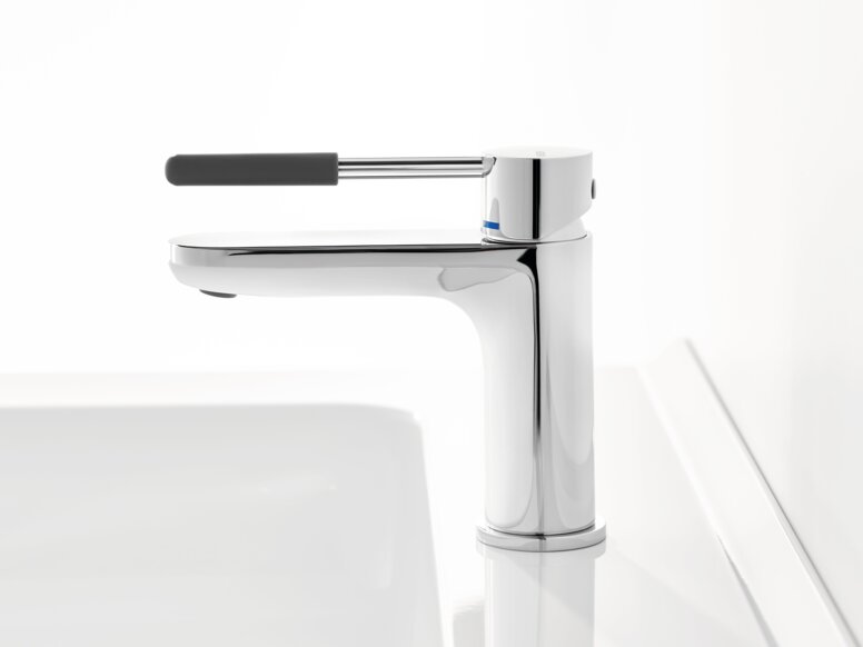 Chrome-plated tap with a long lever handle and dark grey grip sleeve on a white washbasin against a white background