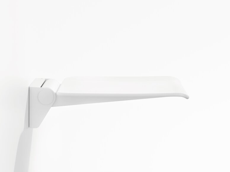 HEWI System 900 hinged seat White wall-mounted hinged seat with a flat seating surface and rounded front edge against a white background, viewed from the side